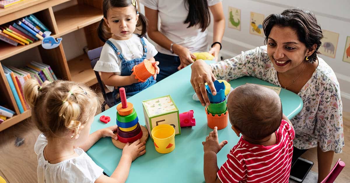 Early childhood educator supporting children during a play-based learning activity