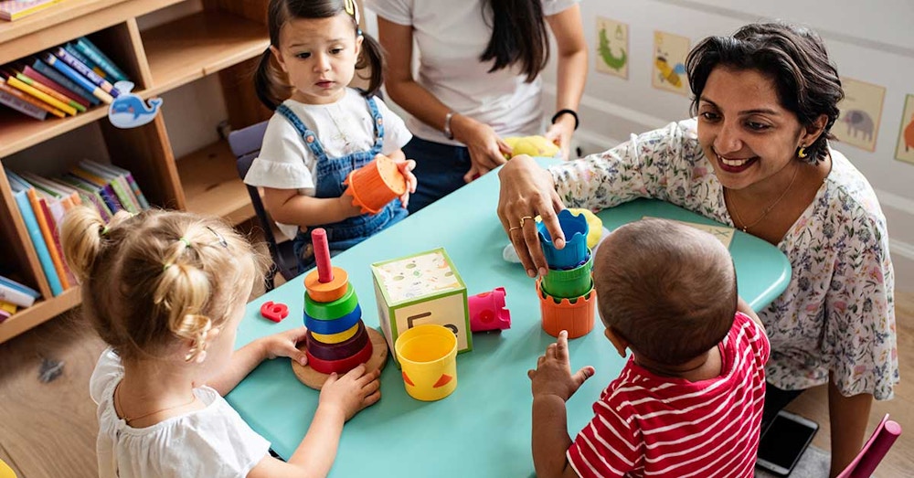 Early childhood educator supporting children during a play-based learning activity