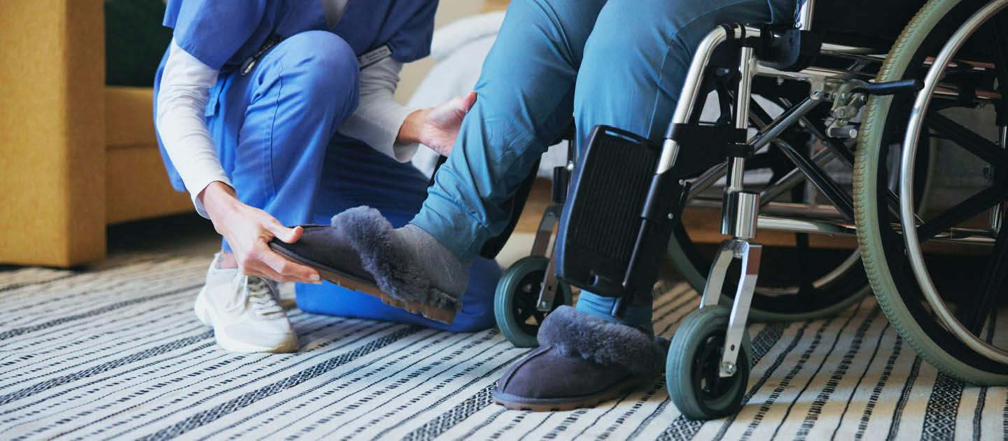 Disability support worker assisting a person using a wheelchair with everyday personal support