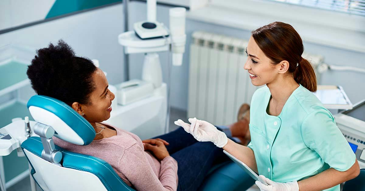 Dental assistant speaking with a patient in a dental clinic