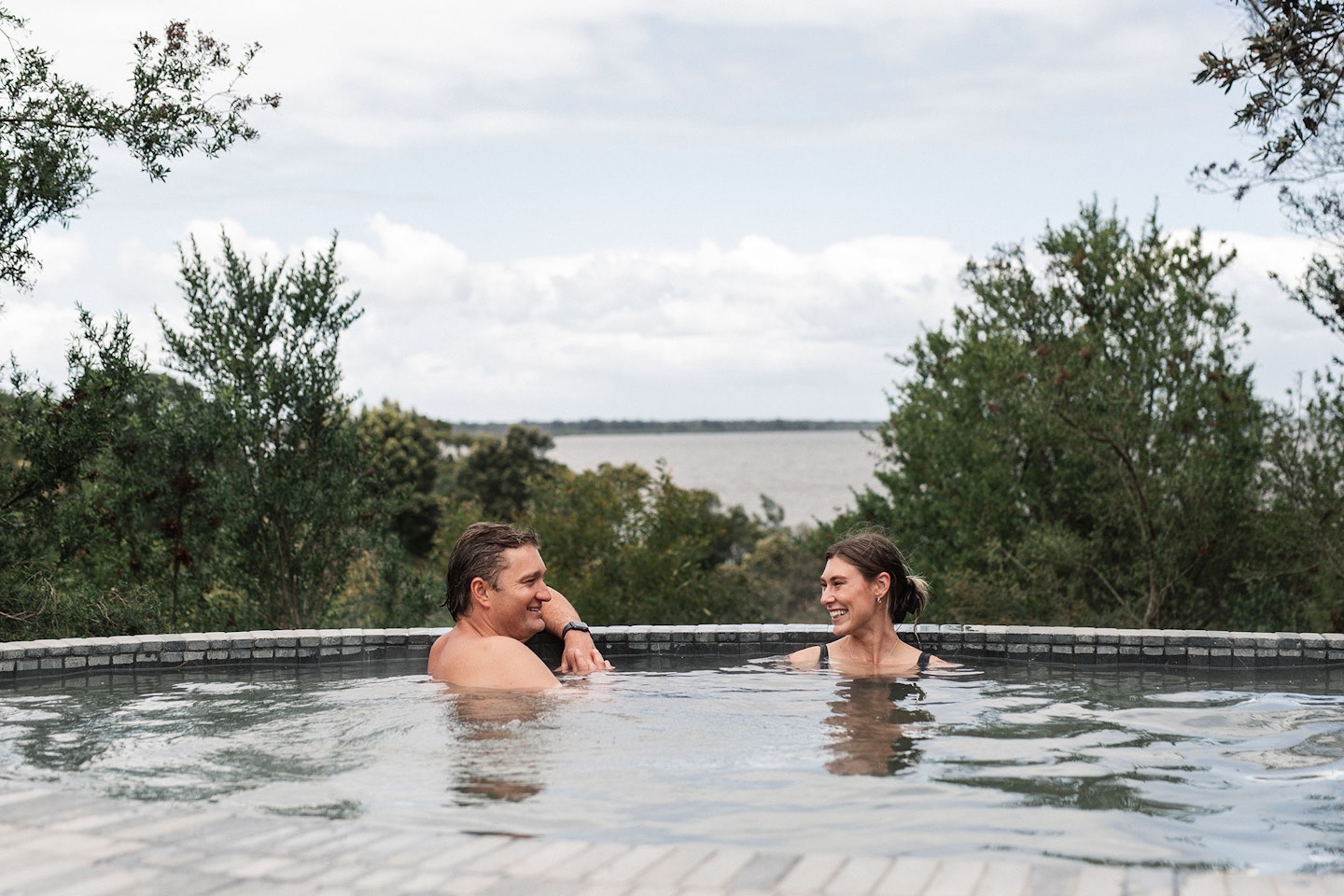 man and woman bathing in geothermal hot springs