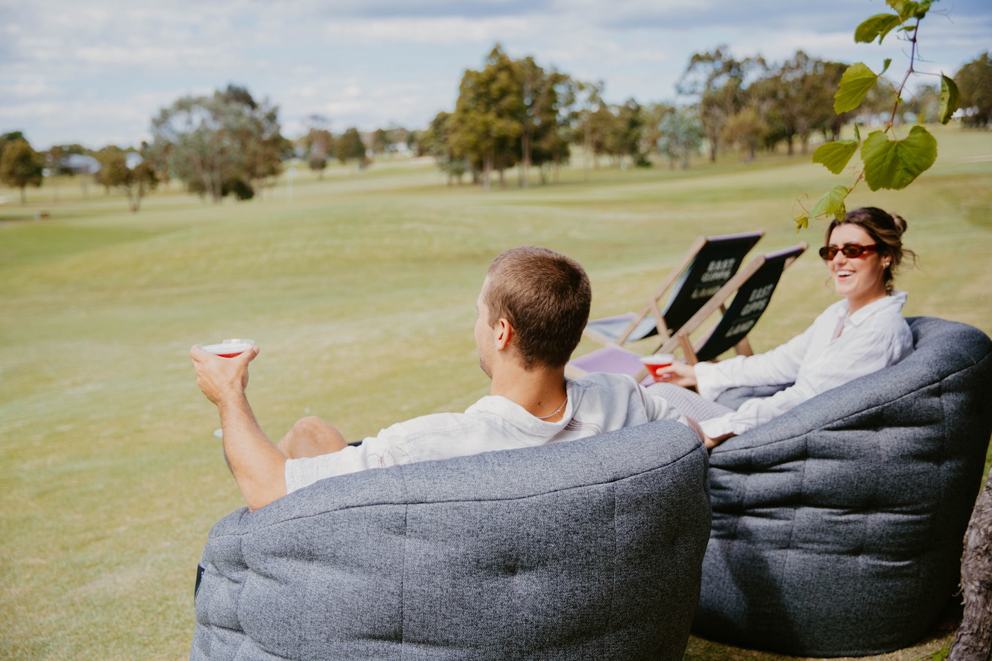 couple drinking cocktails overlooking golf course
