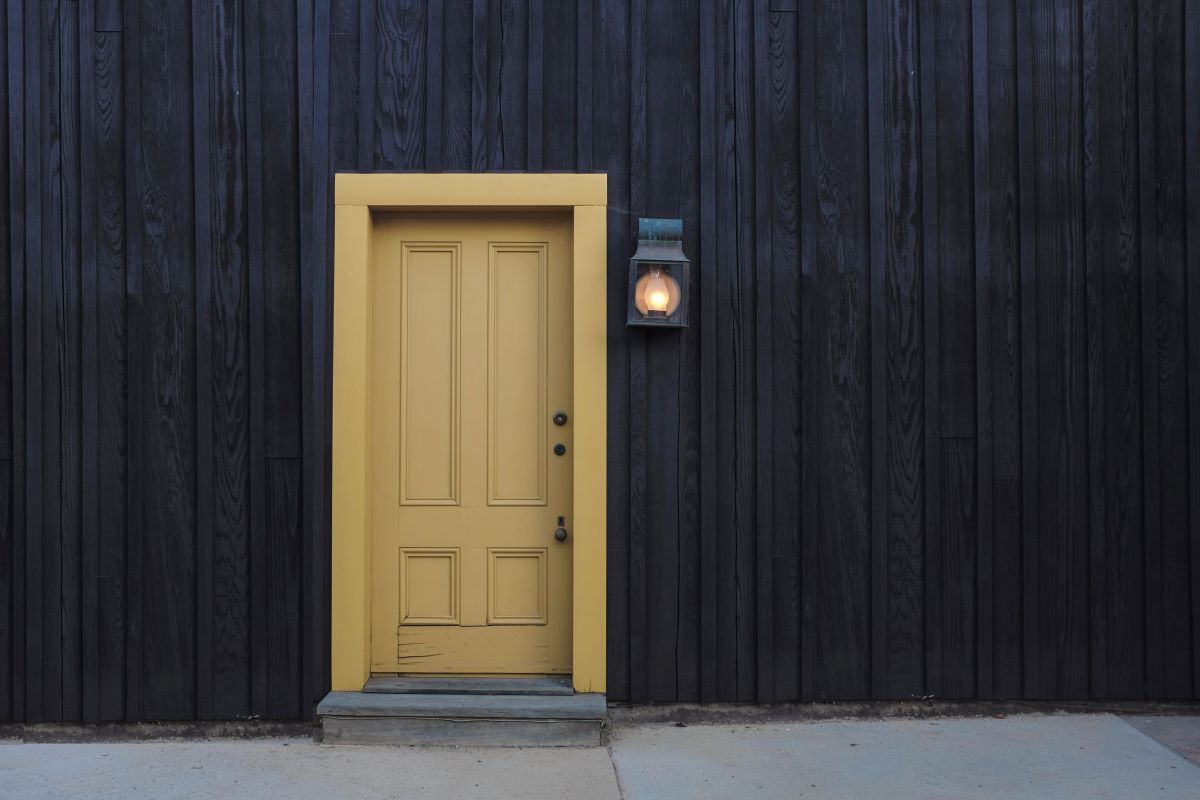 L'image représente la porte d'entrée d'un appartement dans lequel le locataire rédige une lettre de résiliation de son bail.