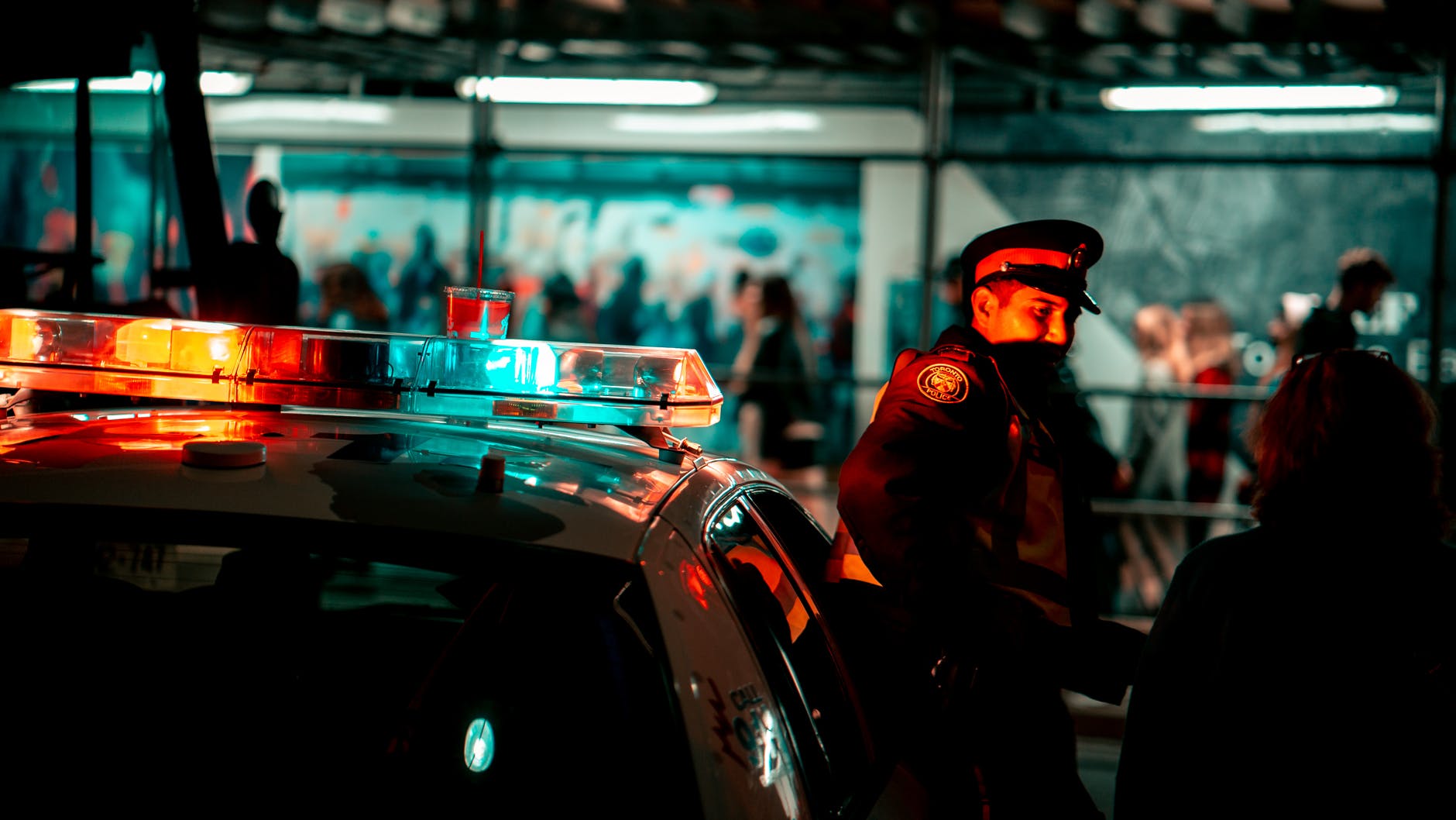 voiture de police avec un agent de police dans la nuit