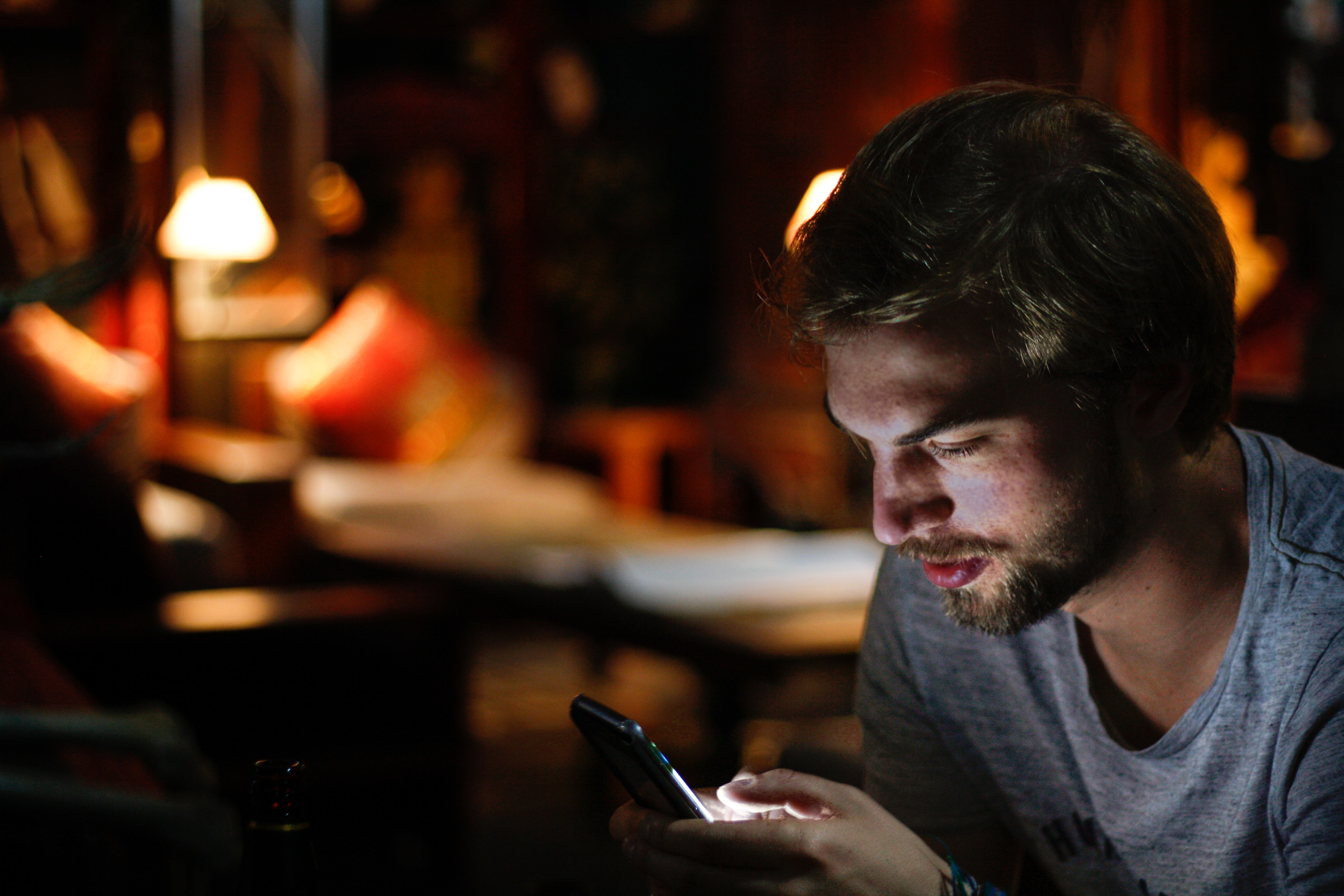 Homme consultant un smartphone dans le noir 