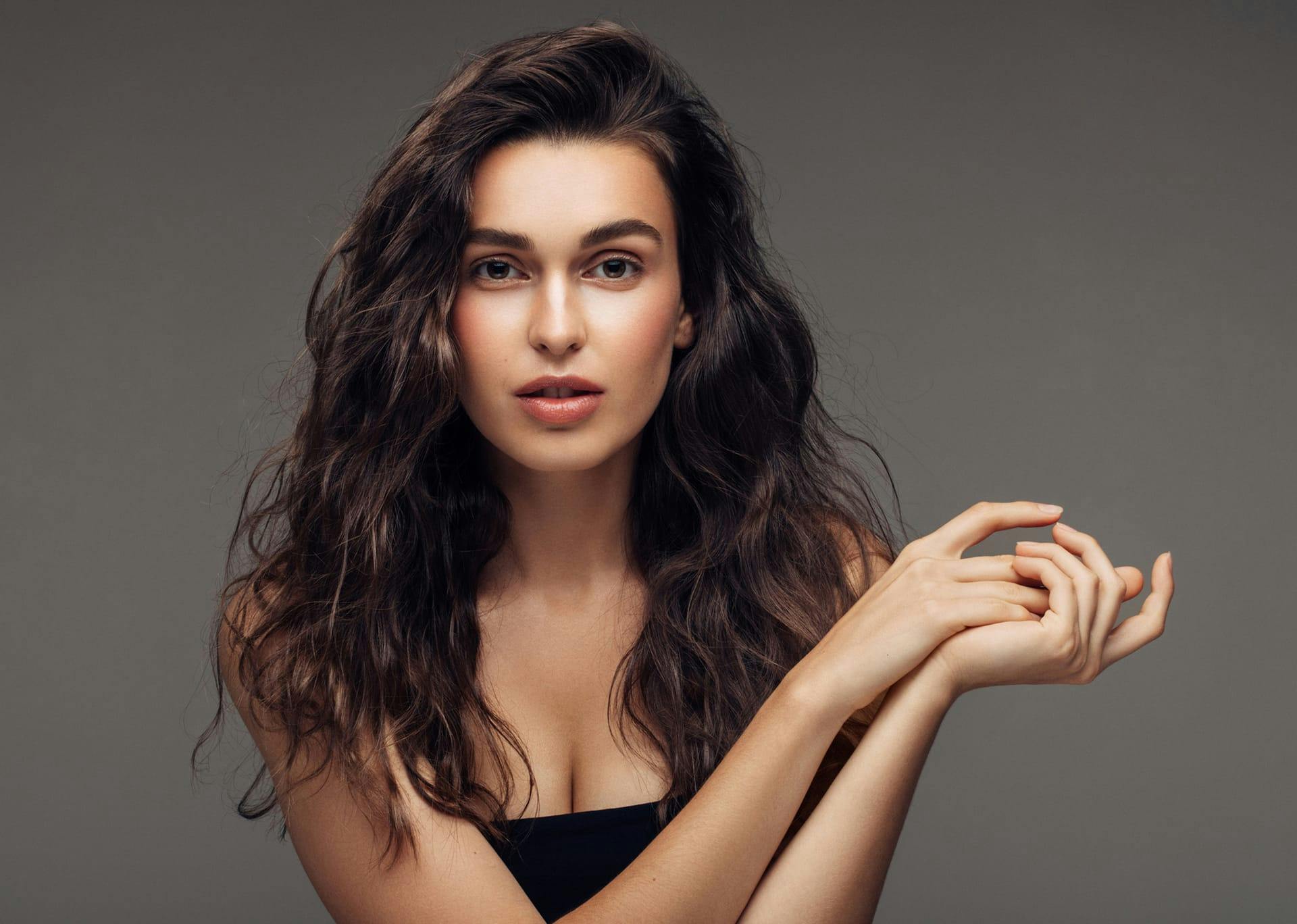 Beautiful woman staring into the camera with hands clasped.