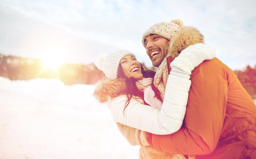 Mann og kvinne er glade ute i snøen.
