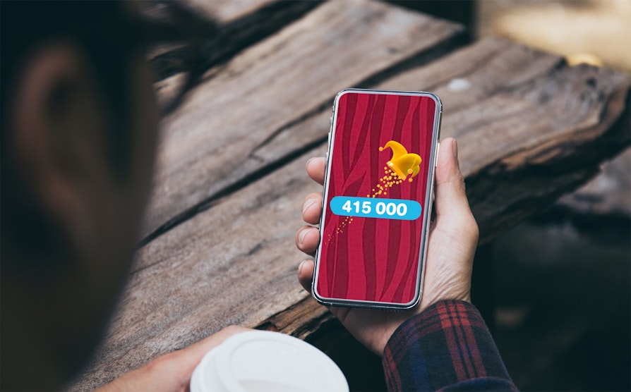 Mann som holder telefon som viser premiesum