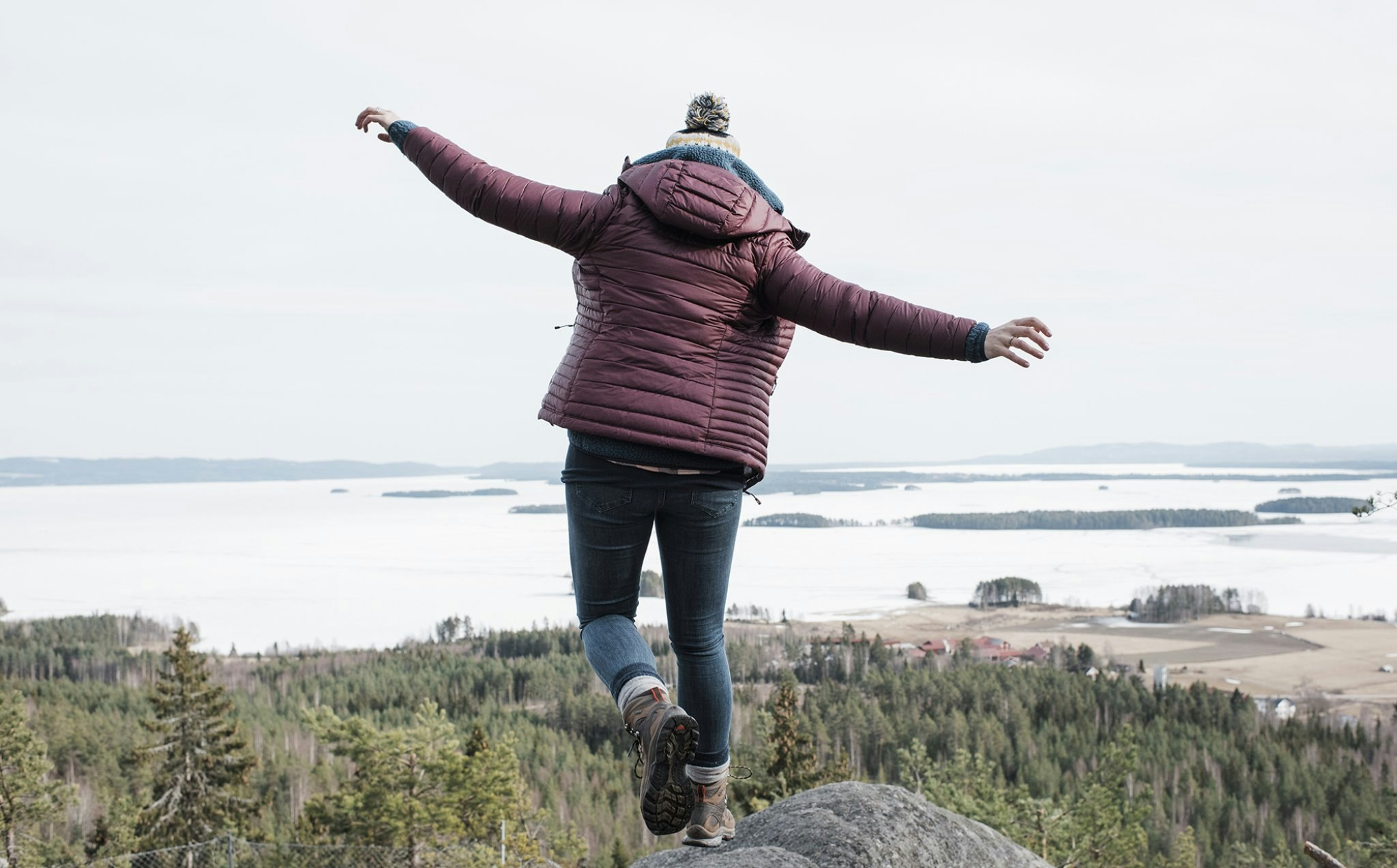 Kvinne løper på et fjell ved havet