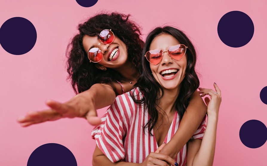 To glade jenter med solbriller i Lotto-fargen rød.