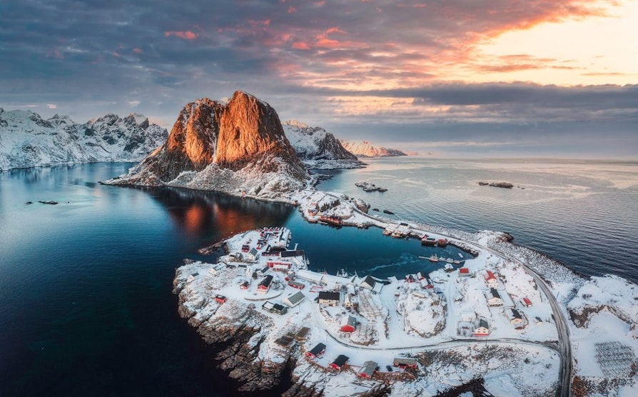 Landskapsbilde av snødekte Lofoten i solnedgang