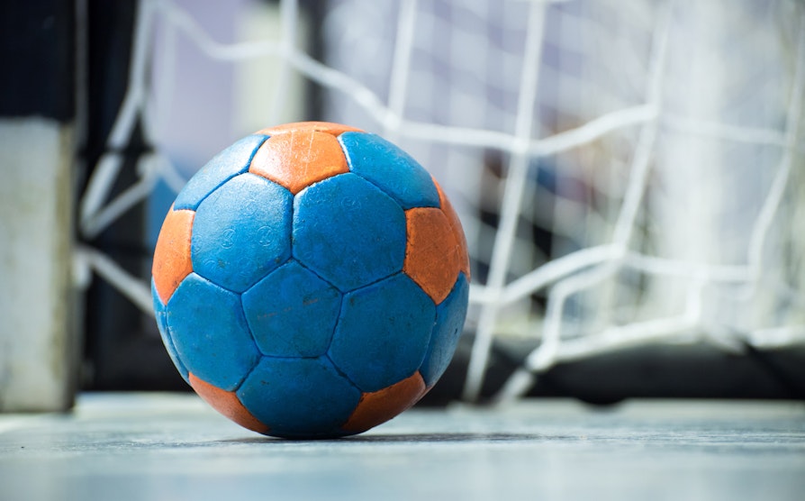 Nærbilde av håndball som ligger på gulv foran mål