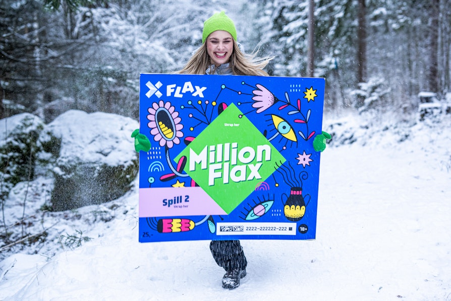Kvinne som ler og løper gjennom vinterskog bærende på et overdimensjonert MillionFlax-lodd