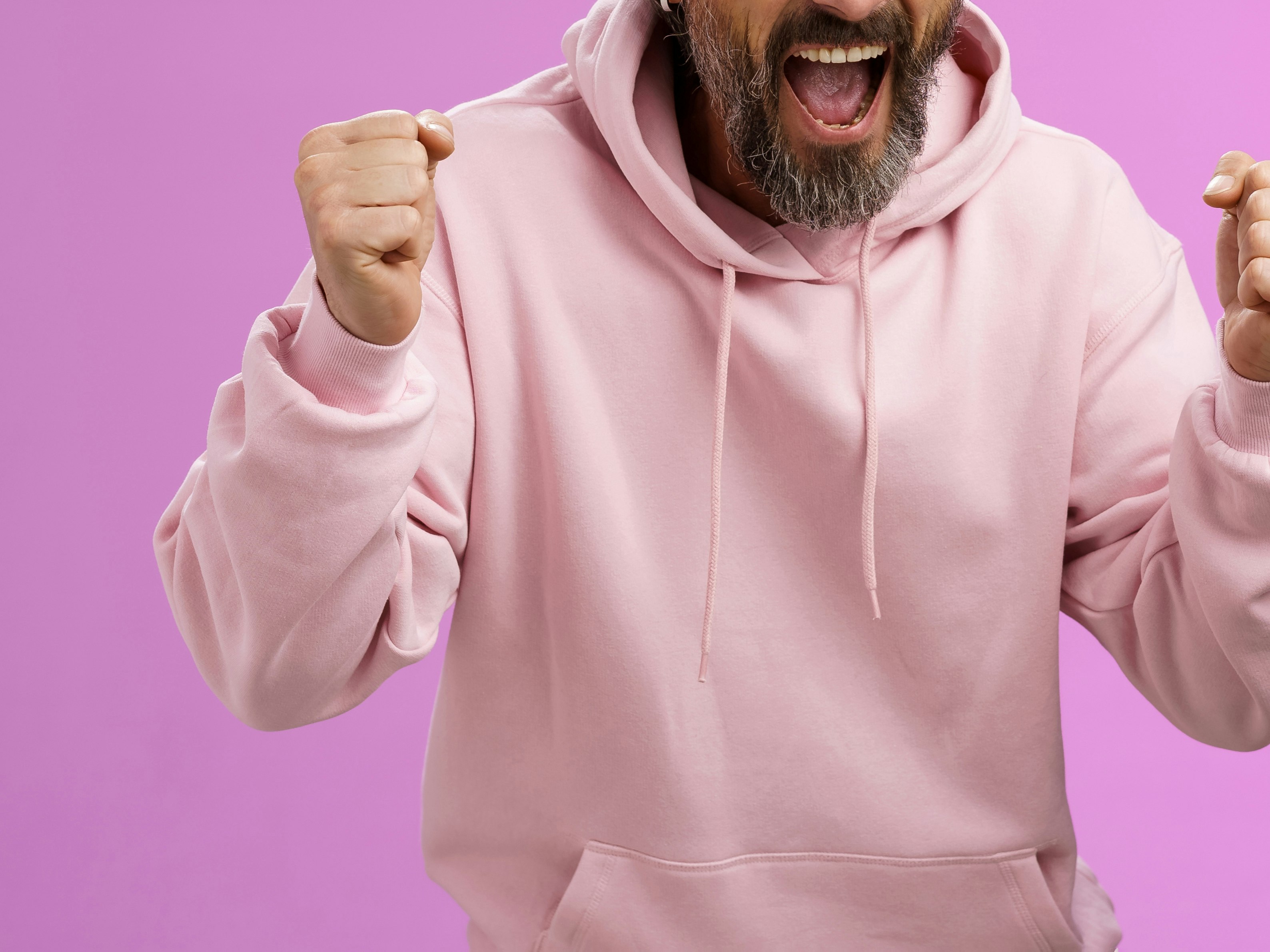 Illustrasjonsfoto, utsnitt av mann i rosa genser som jubler mot lilla bakgrunn