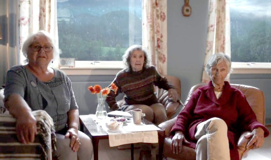De tre venninnene sitter inne i regnet i en av «A Room With A View filmene».