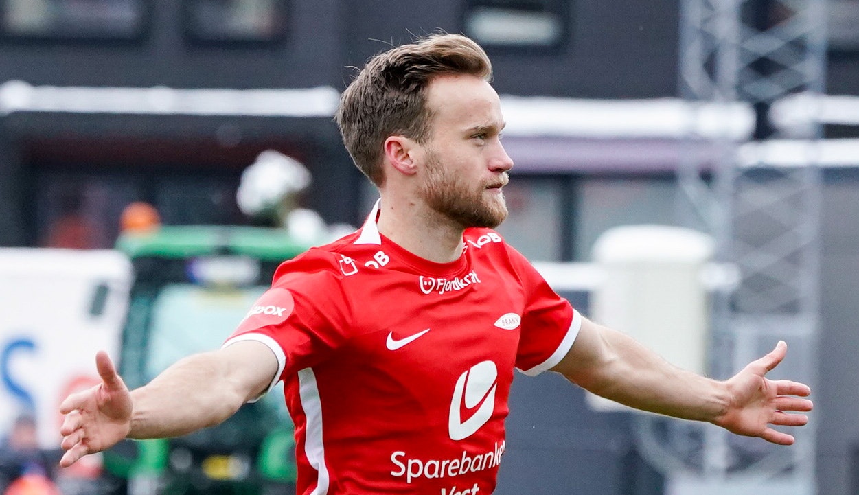 Fotballspiller i rød drakt feirer scoring