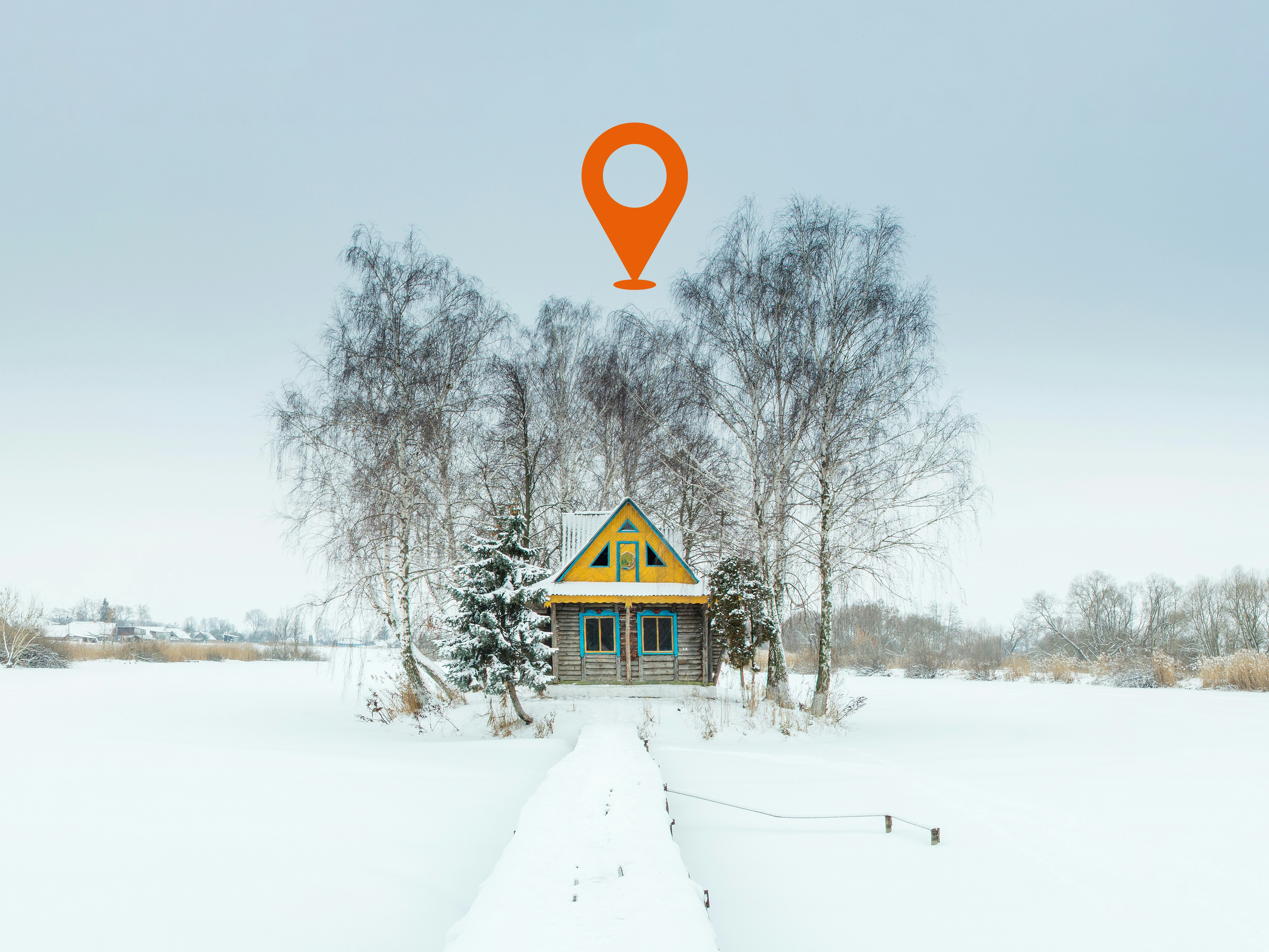 Illustrasjonsfoto av lite gult og blått hus i vinterlandskap, sentrert i bilde mellom små bjørketrær. En oransje geotag flyter over huset.