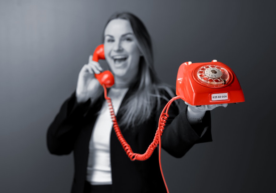 Norsk Tipping-ansatt Pie Skagsoset Norseng med rød telefon. Lotto.