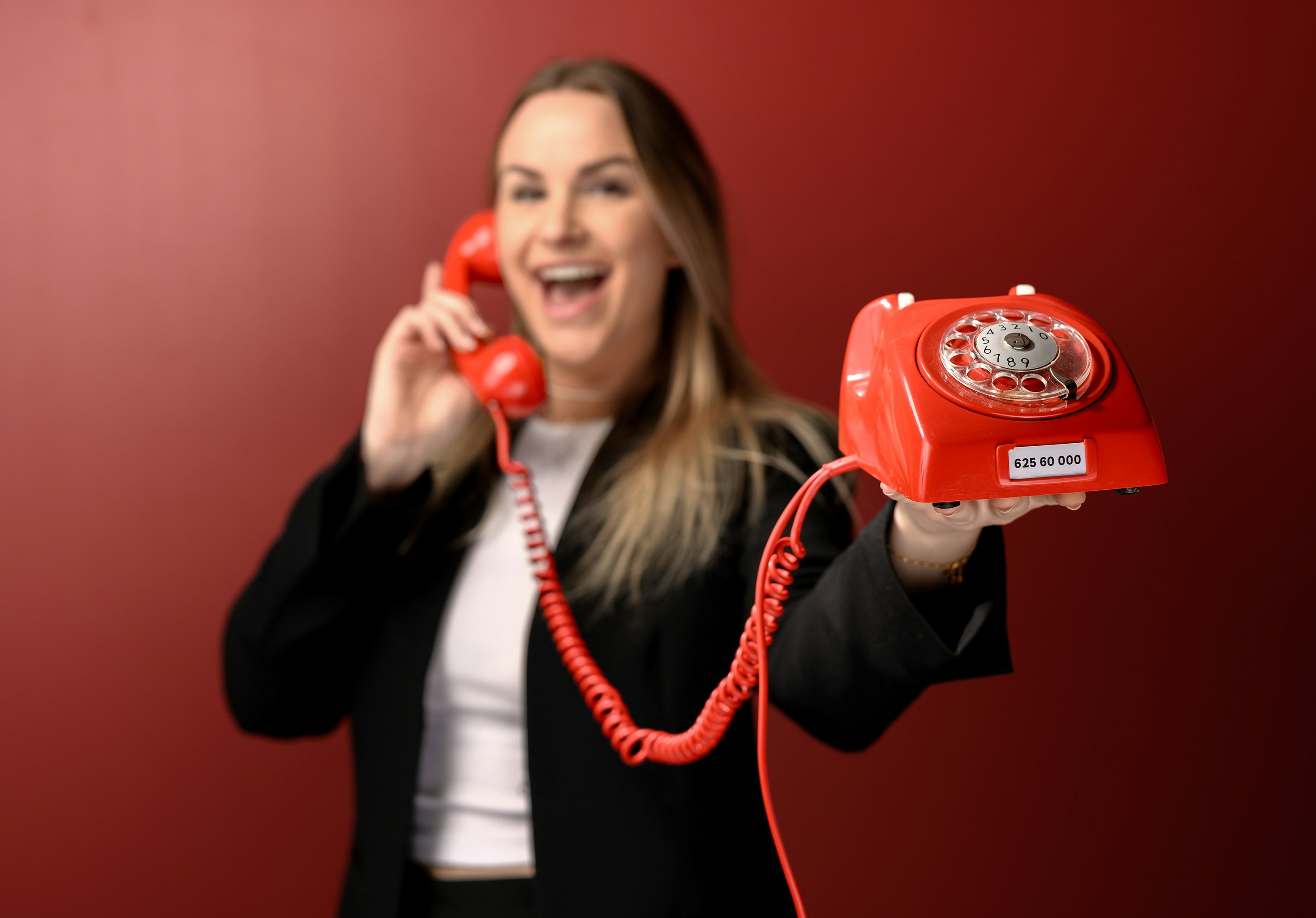 Norsk Tipping-ansatt Pie Skagsoset Norseng med rød telefon. Lotto.