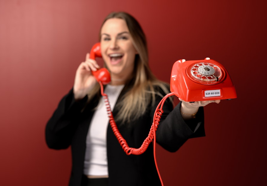 Norsk Tipping-ansatt Pie Skagsoset Norseng med rød telefon. Lotto.