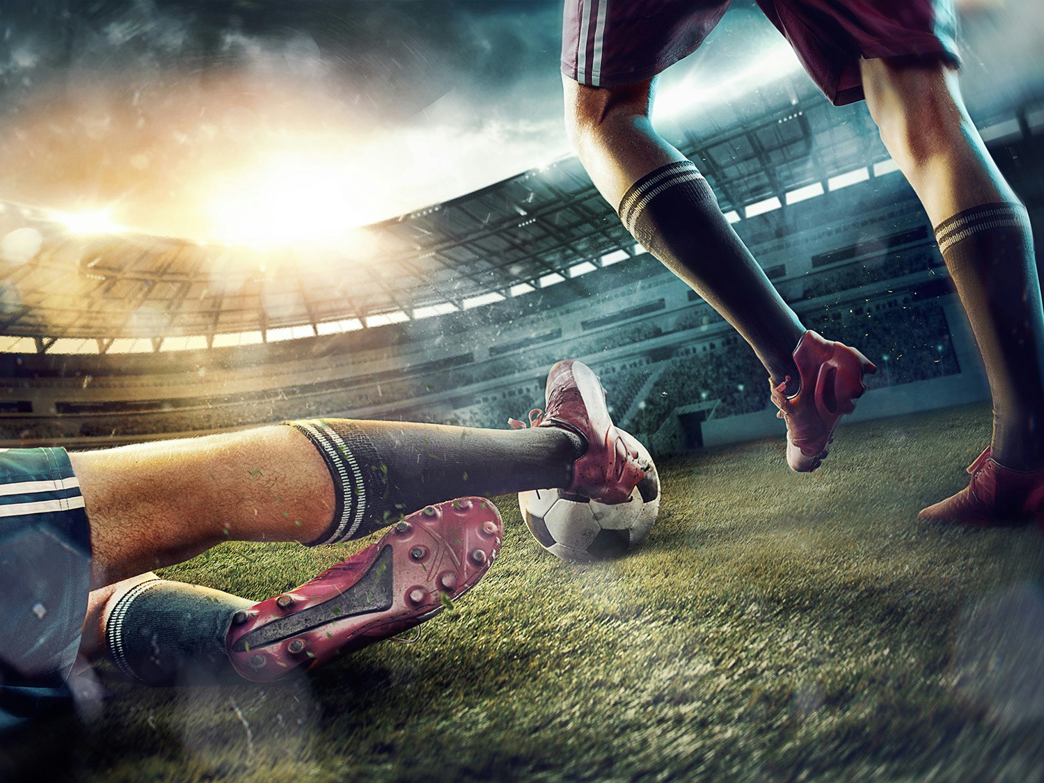 Fotball. Beina på to fotballspillere og en fotball
