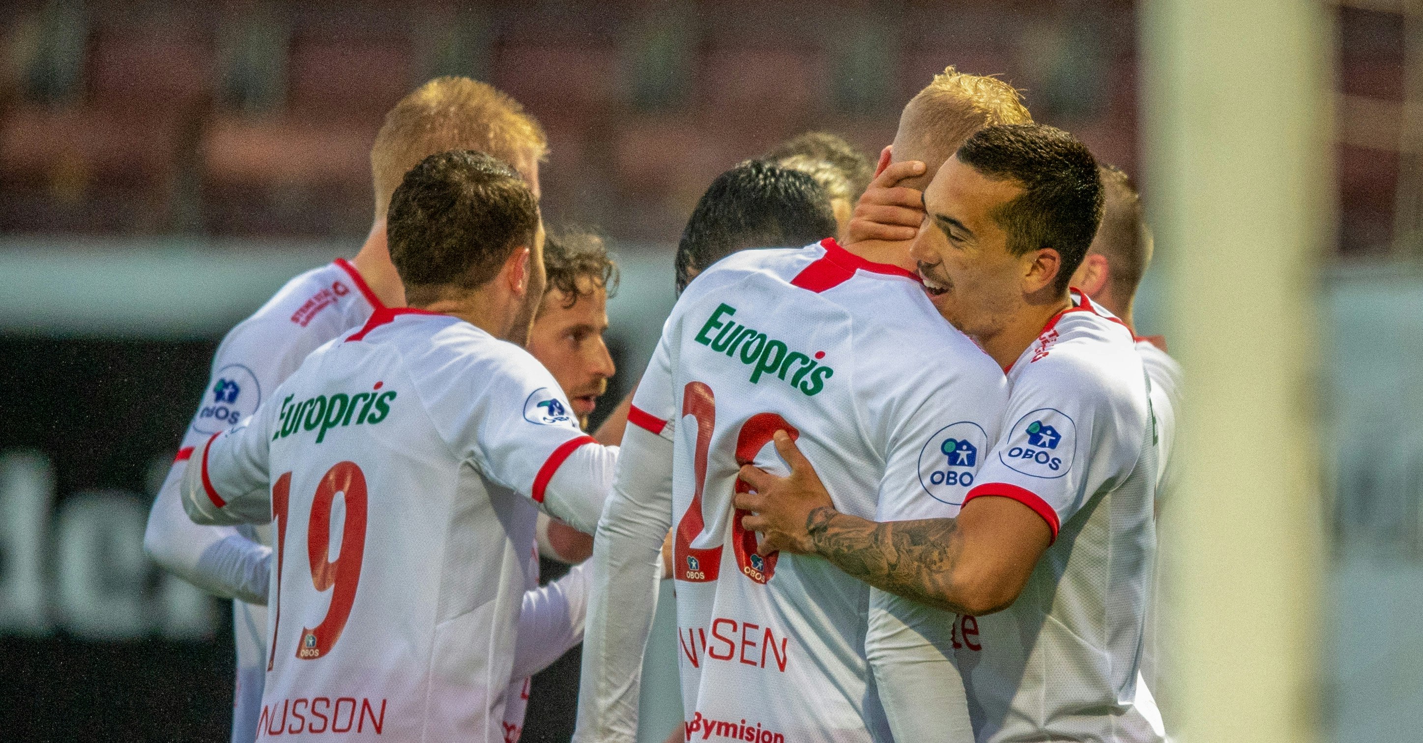 Fotballspillere i hvite drakter jubler etter scoring.