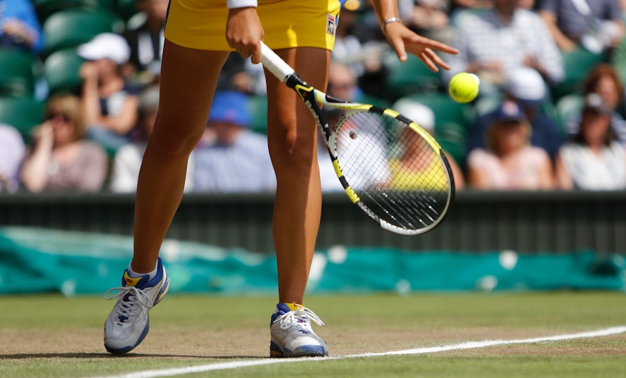 Tennis-spiller med ball på gressbane