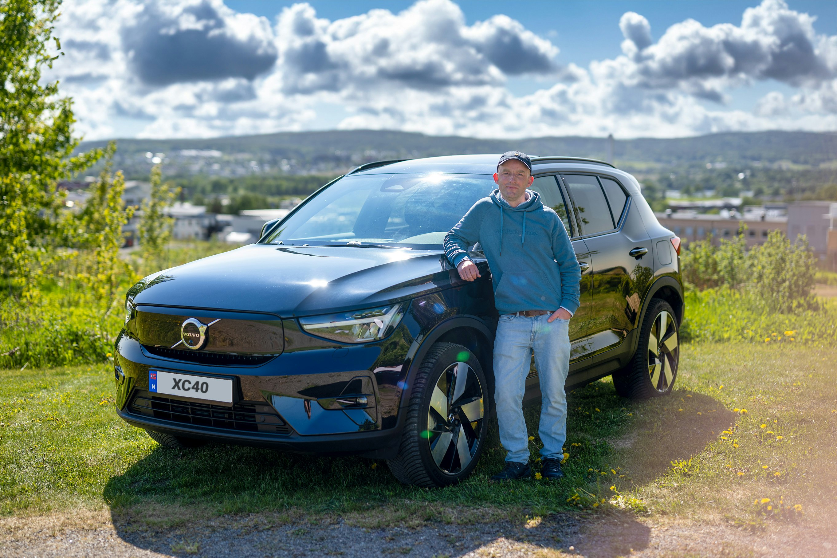 BilFlax-vinner Kristian Skoge står foran en sort  Volvo XC40 foran industrilandskap.