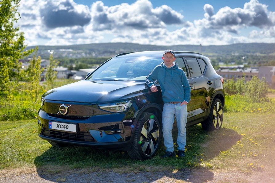 BilFlax-vinner Kristian Skoge står foran en sort  Volvo XC40 foran industrilandskap.