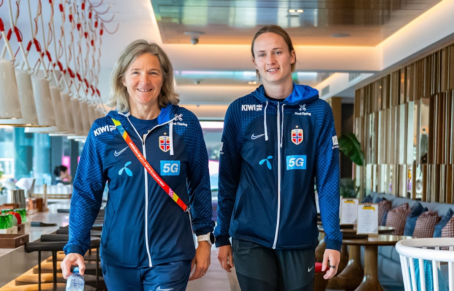 Norges landslagstrener Hege Riise og spiller Caroline Graham Hansen kommer gående i blå treningsdresser.