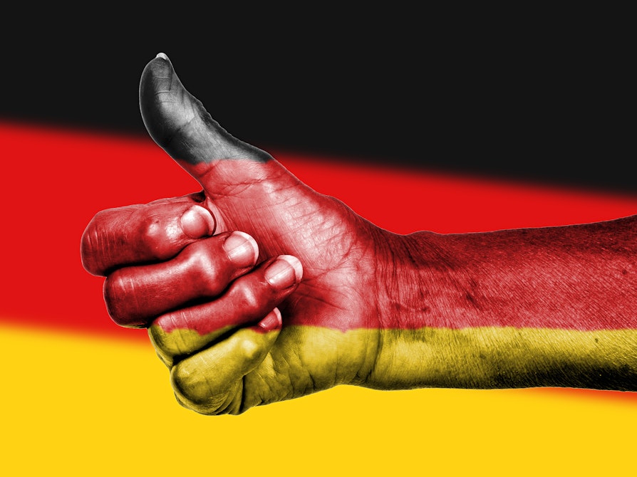 Hånd påmalt det tyske flagget viser tommel opp foran det tyske flagget.