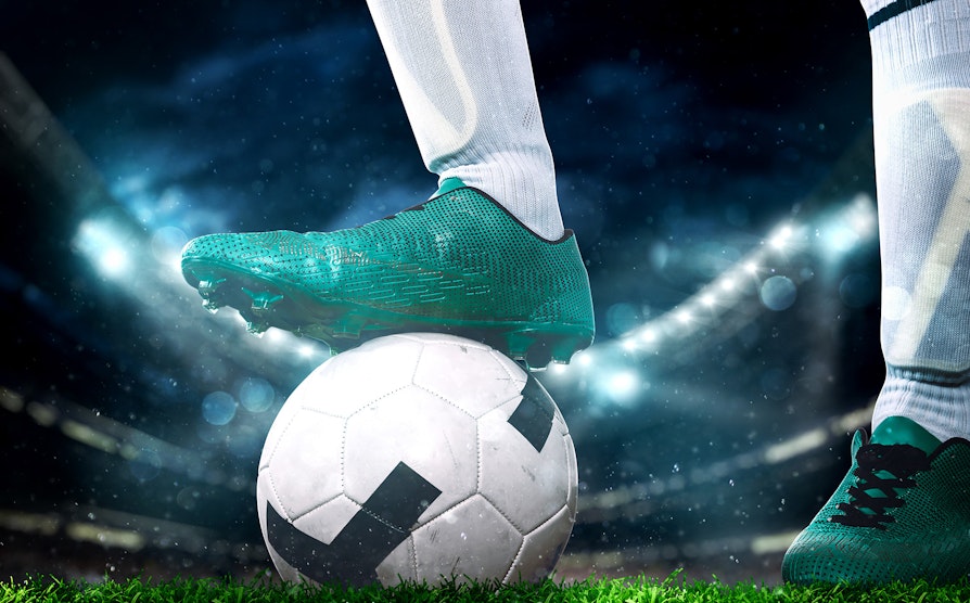 Fot med fotballsko på en fotball
