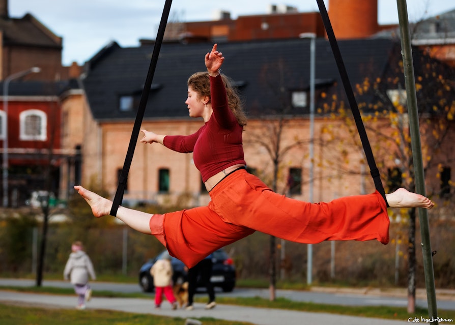 Bilde av ung kvinne som utfører akrobati utendørs.