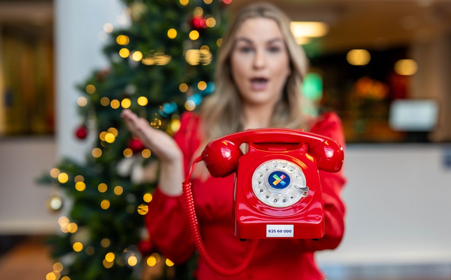 Kvinne holder den røde Telefonen fra Hamar