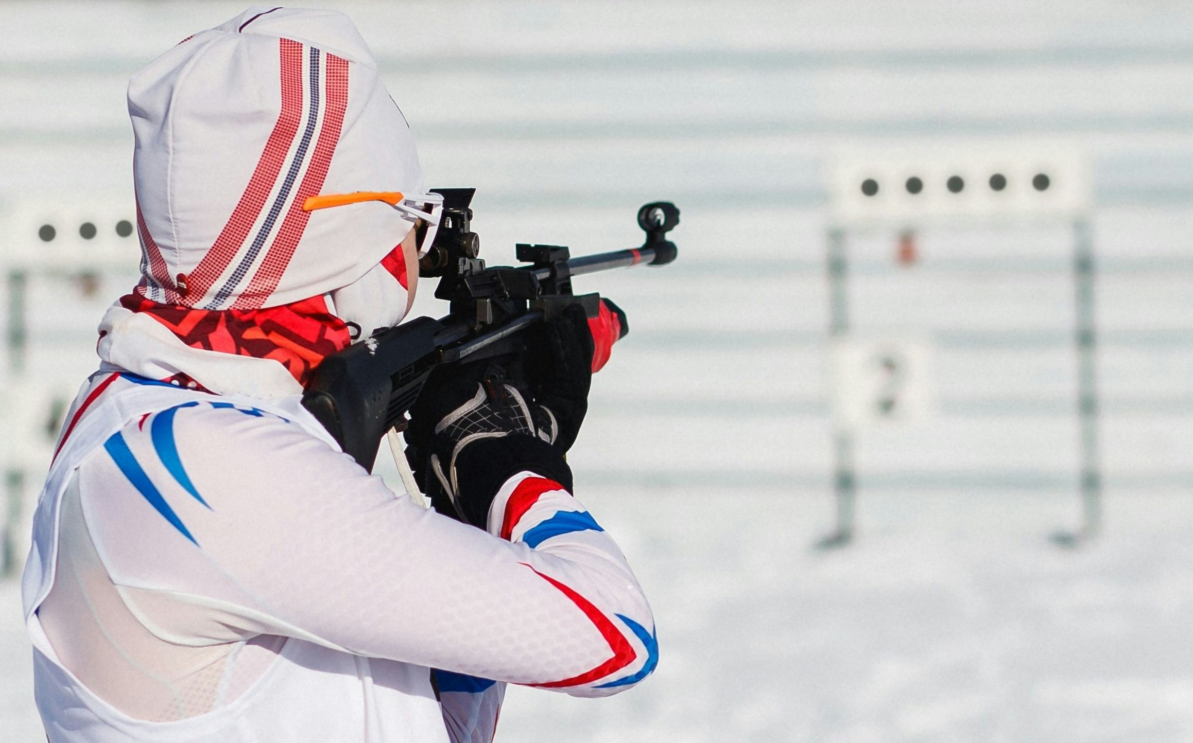 Bilde av en skiskytter på standplass. Bildet tatt bakfra.
