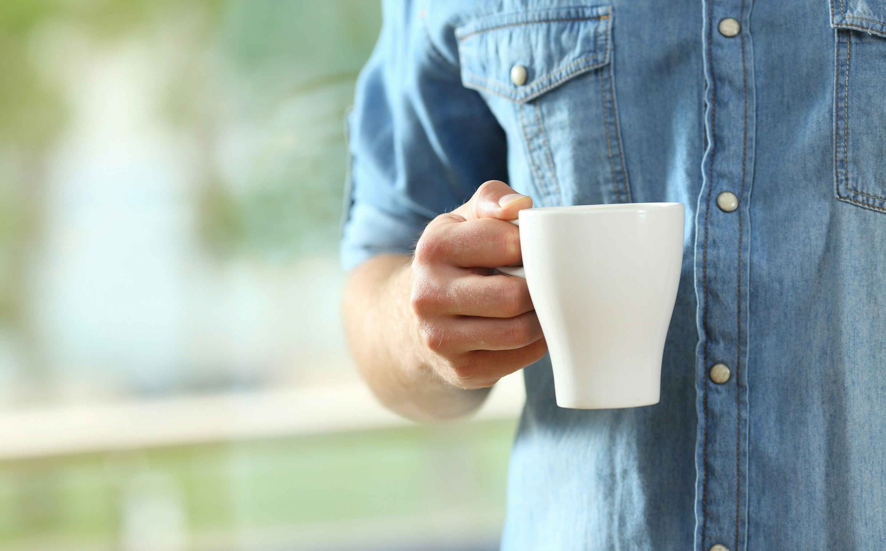 Hånd holder kaffekopp