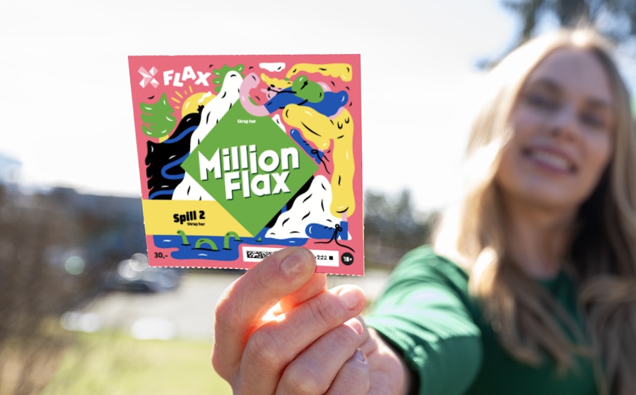 Halvsnitt av kvinne med blondt langt hår og grønn genseri ufokus som holder opp et MillionFlax foran vårlig bakgrunn.