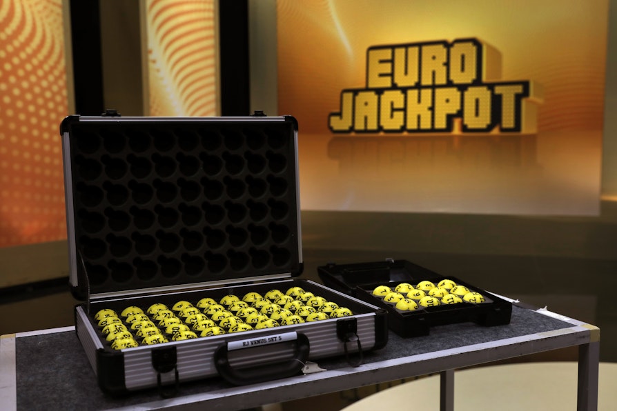 Bilde av tv-studioet der Eurojackpot trekkes. Koffert med kuler foran i bildet, bak skjermvegger med Eurojackpot-logo.
