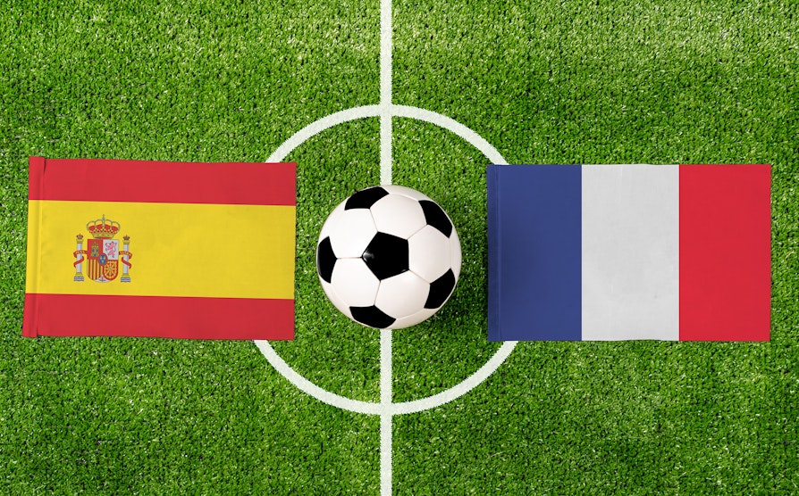 Spansk og Fransk flagg side om side på en fotballbane ifm. fotball-EM 2024.