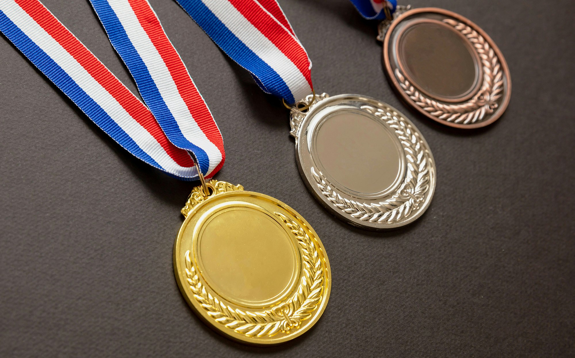 Tre medaljer ved siden av hverandre. OL 2024.