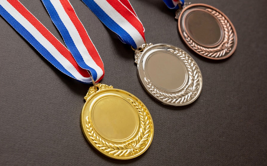 Tre medaljer ved siden av hverandre. OL 2024.