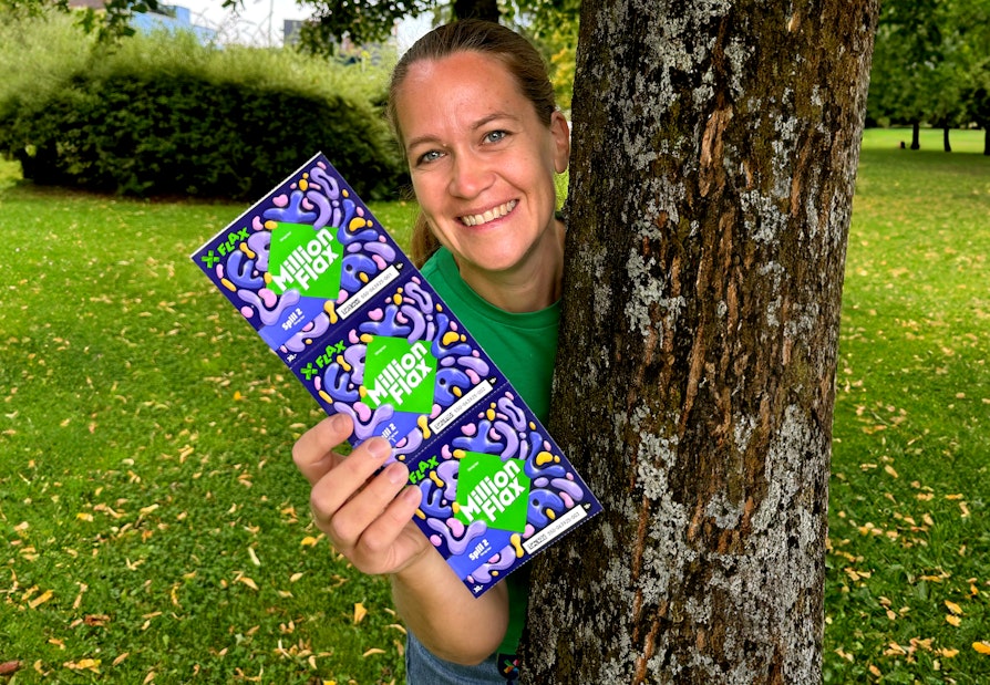 Bilde av Rita Oddseter i Norsk Tipping. Holder fram MillionFlax-lodd. Høstlodd 2024.