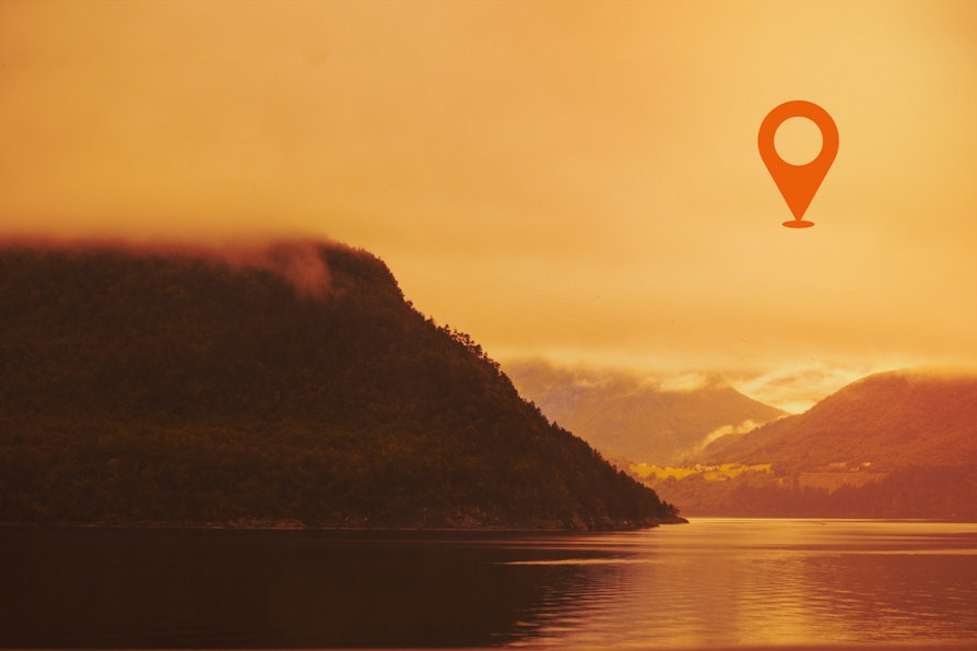 Norsk fjell- og fjordlandskap i solnegang i oransje toner med oransj Nabolaget-geotag øverst til høyre.