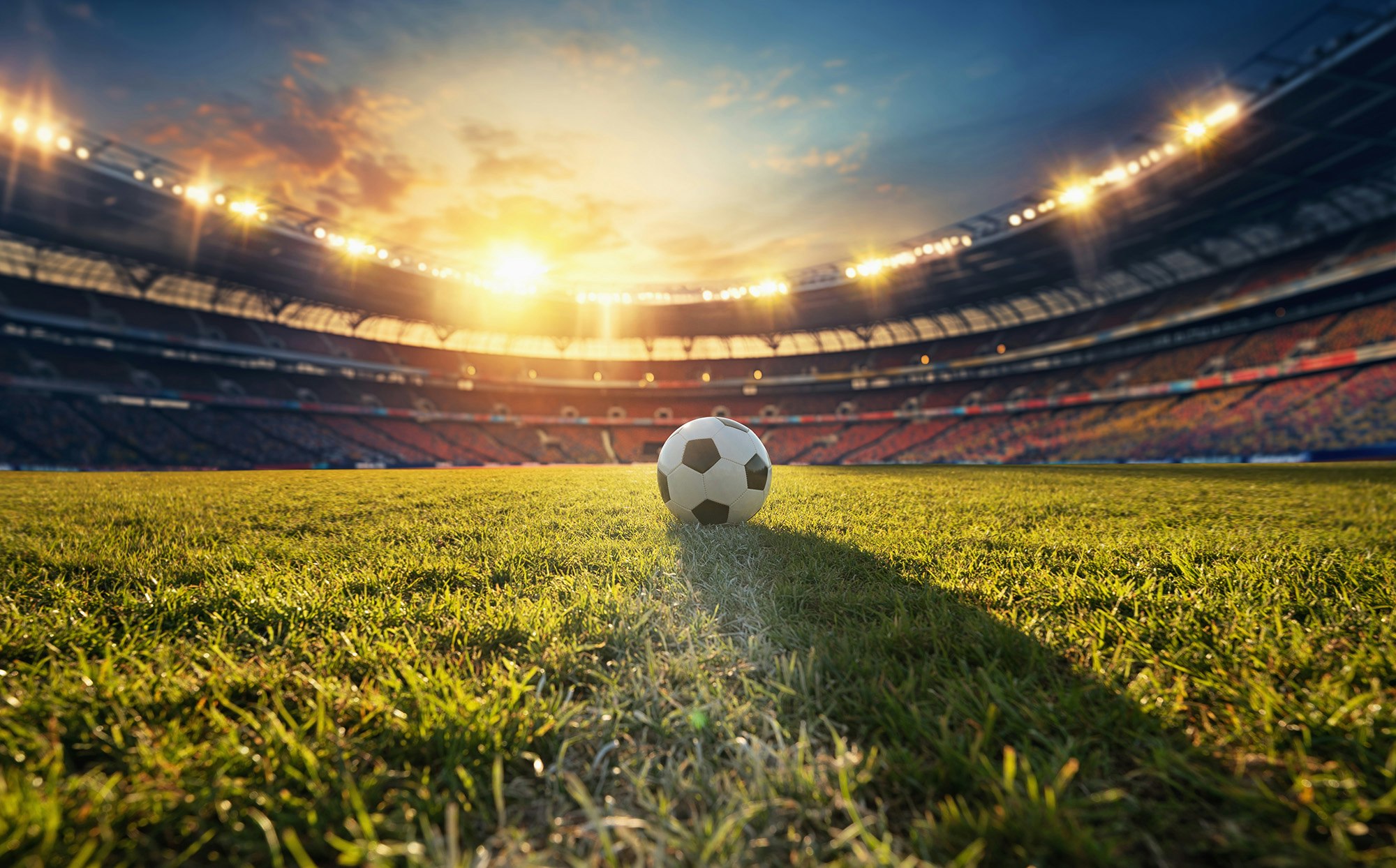Fotball midt på gressbanen inne på fotballstadion.