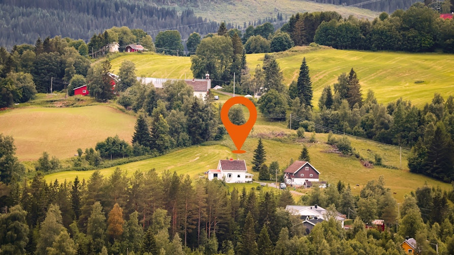 Landskapsbilde av jorder, skog og gårder om høsten i Innlandet.