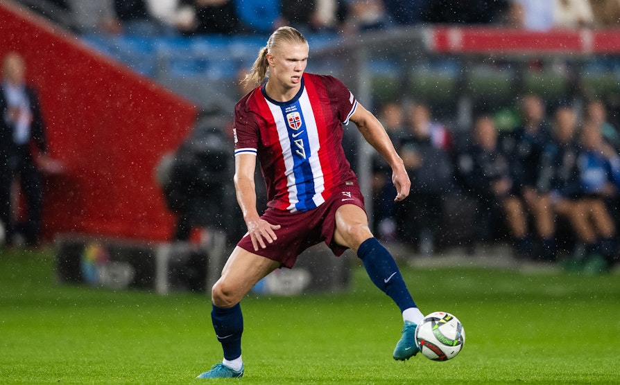 Erling Braut Haaland i landslagsdrakt sparker en fotball.