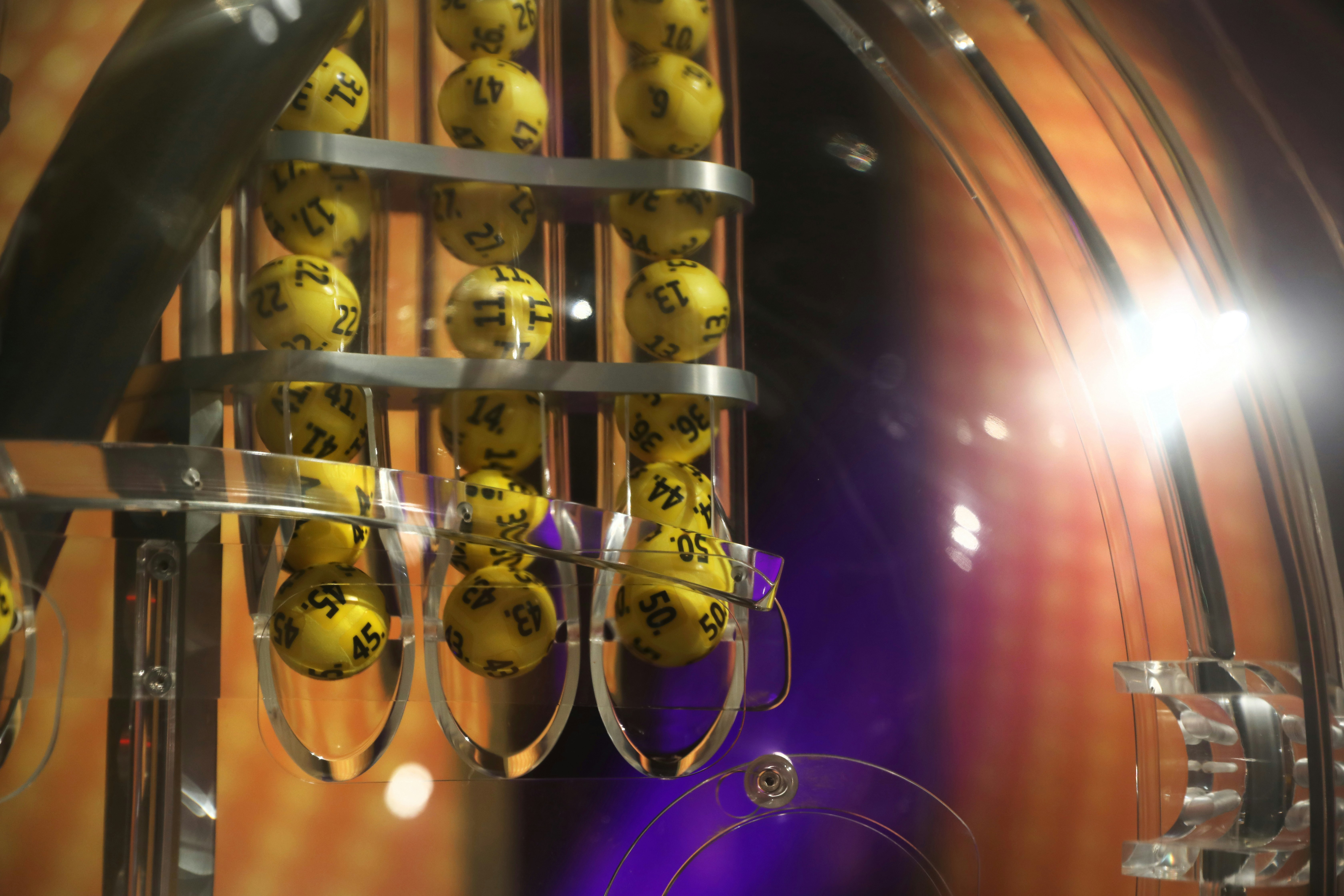 Bilde av trekningsmaskin Eurojackpot. Bilde av gule kuler i maskinen, før de faller ned i maskinen og blir trukket.