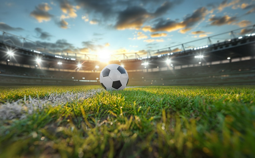 Fotball ligger på gresset på fotballstadion