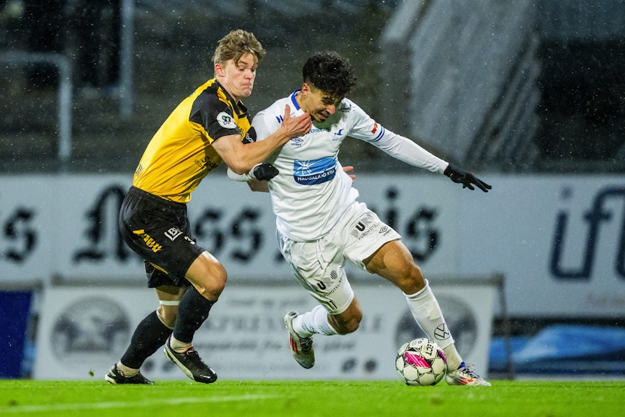 Bilde av fotballspillere i kamp på Melløs stadion torsdag 5. desember 2024. Moss Kristoffer Lassen Harrison til venstre og Haugesunds Sebastian Tounekti. Første kvalikkamp av to for spill i eliteserien. Det endte 0.-0 i første kamp.