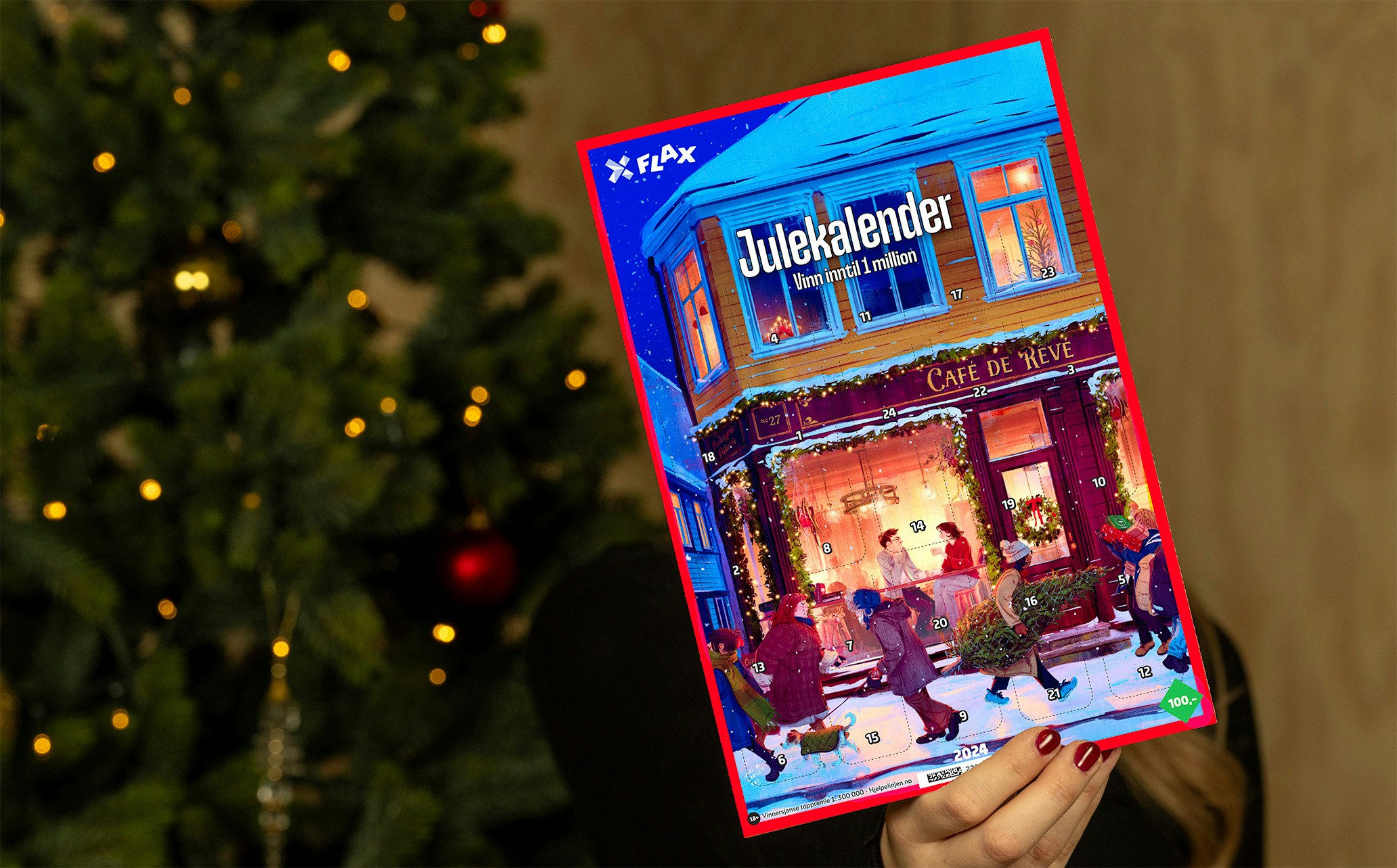 Person holder Flax Julekalender. Juletre i bakgrunnen